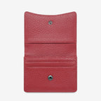 The Status Anxiety Lumen Wallet in Rouge open on a blank background