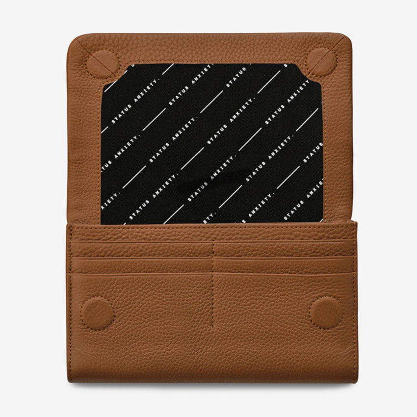 The Status Anxiety Remnant Wallet in Camel open on a blank background