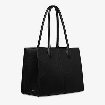 A side view of the Status Anxiety Without Warning Bag in Black on a grey background