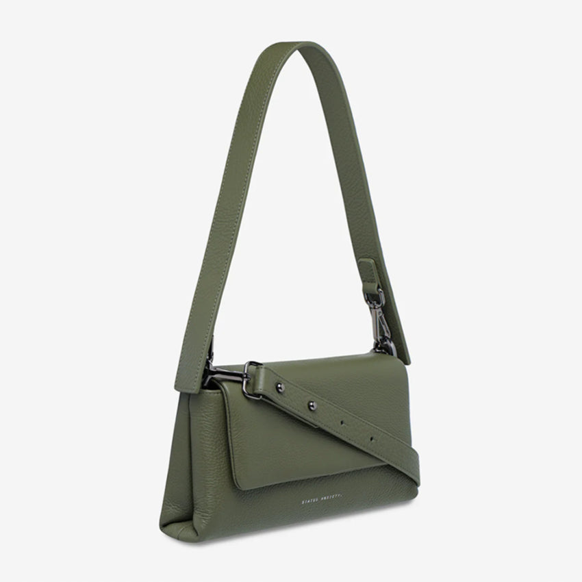 The Status Anxiety Zenith Bag in Khaki on a blank background with the long strapped wrapped around