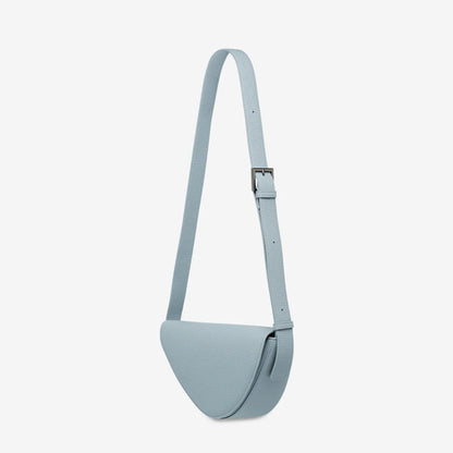 The side profile of the Status Anxiety Ethereal Handbag in Powder Blue on a blank background