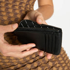 The Status Anxiety Left Behind Wallet in Black with a model opening it
