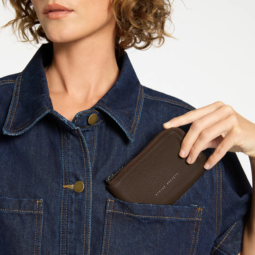 The Status Anxiety Left Behind Wallet in Cocoa with a model putting it in their shirt pocket