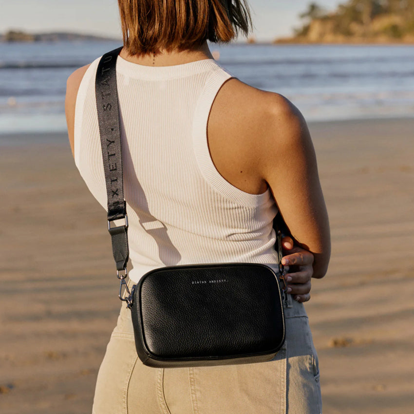 A model wearing the Status Anxiety Plunder Bag with Webbed Strap in Black