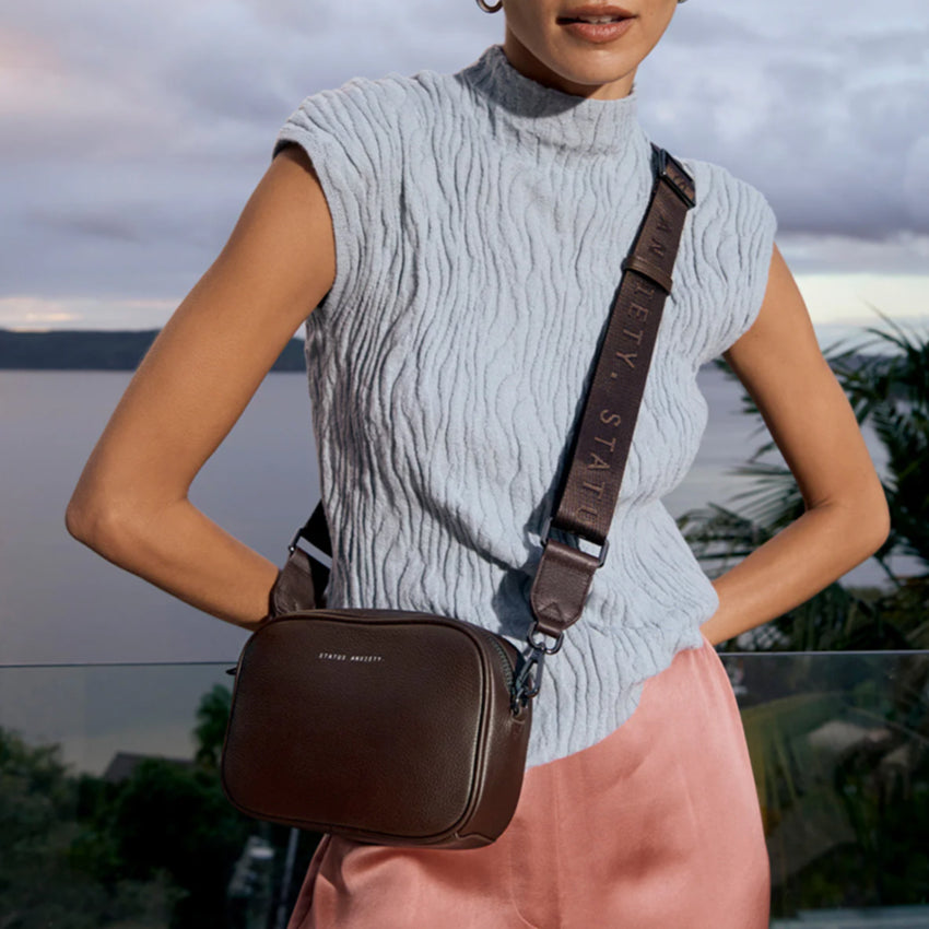 The Status Anxiety Plunder Bag with Webbed Strap in Cocoa on a model