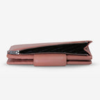 The Status Anxiety Ruins Wallet in Dusty Rose on its side with pocket open on a Blank Background