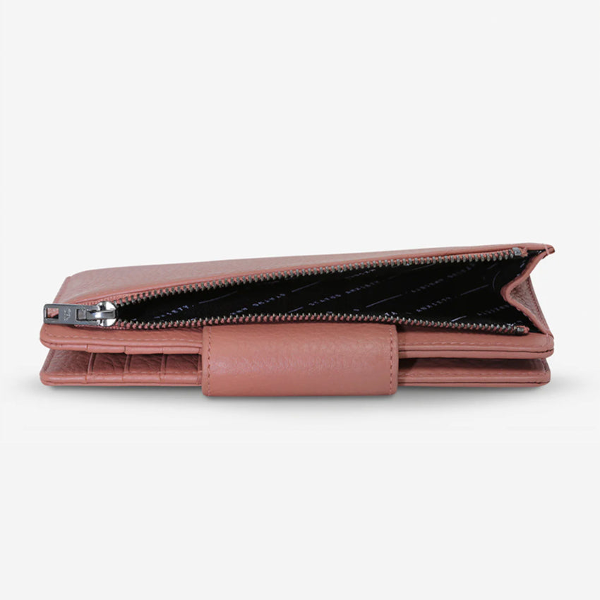 The Status Anxiety Ruins Wallet in Dusty Rose on its side with pocket open on a Blank Background
