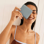 The Status Anxiety Sense Of Wonder Wallet in Powder Blue with a model holding it