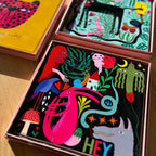 The Studio Soph Hey Art Tile in its box next other art tiles