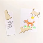 The Suck UK Cat Fridge Magnets holding a drawing and list