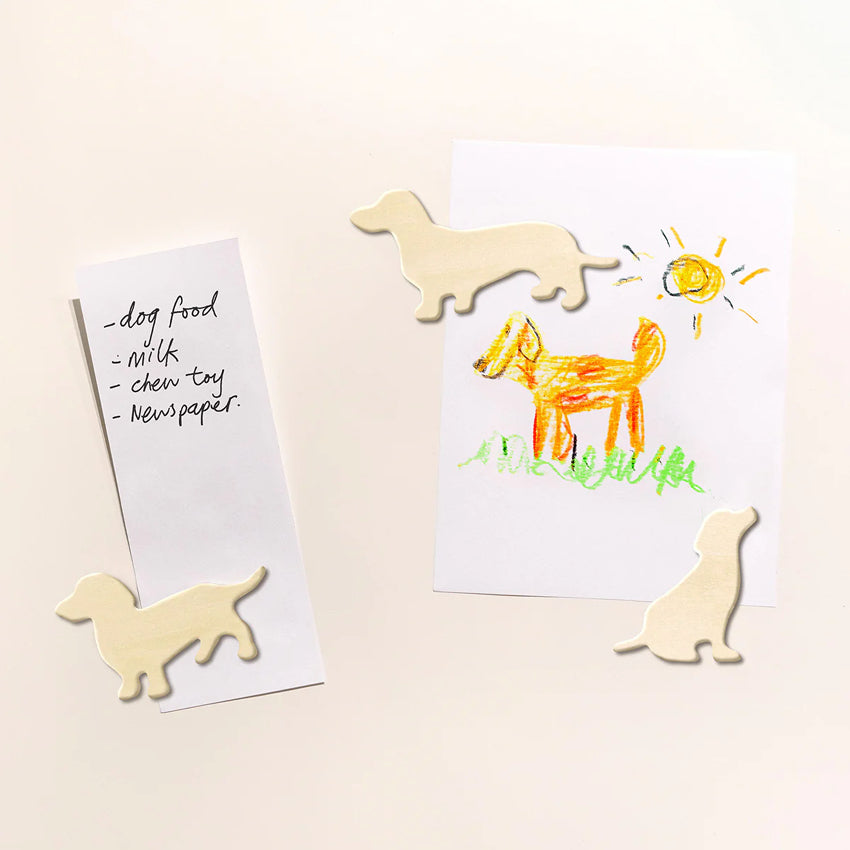 The Suck UK Dog Fridge Magnets holding a drawing and a list