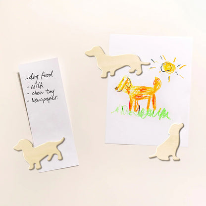 The Suck UK Dog Fridge Magnets holding a drawing and a list