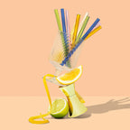 The Sucker Cocktail Straws in Multi in a wine glass balancing on a shot measure and citrus