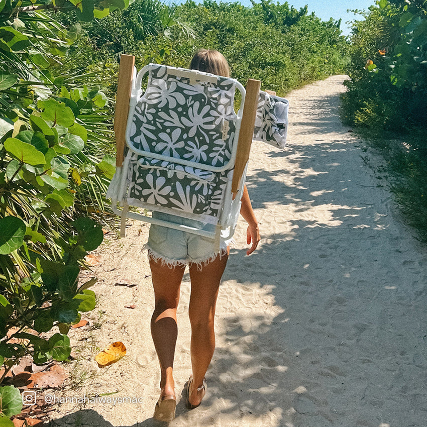 The Sunny Life Luxe Beach Chair in Olive on a girls back walking to the beach