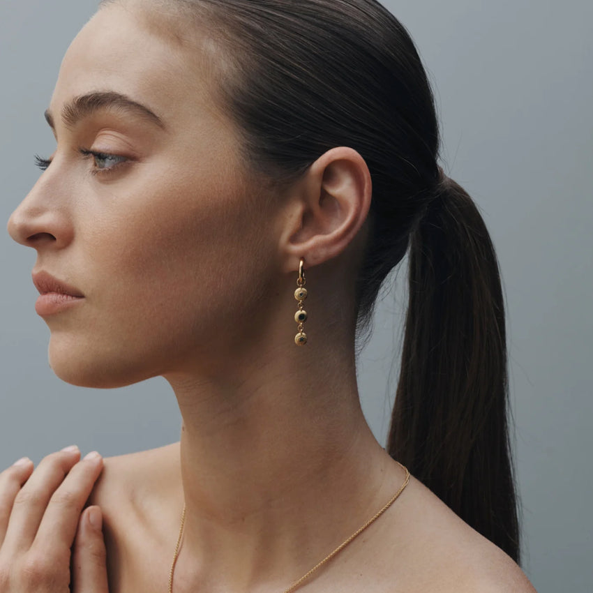 The Temple Of The Sun Blessing Earrings in Gold on a model