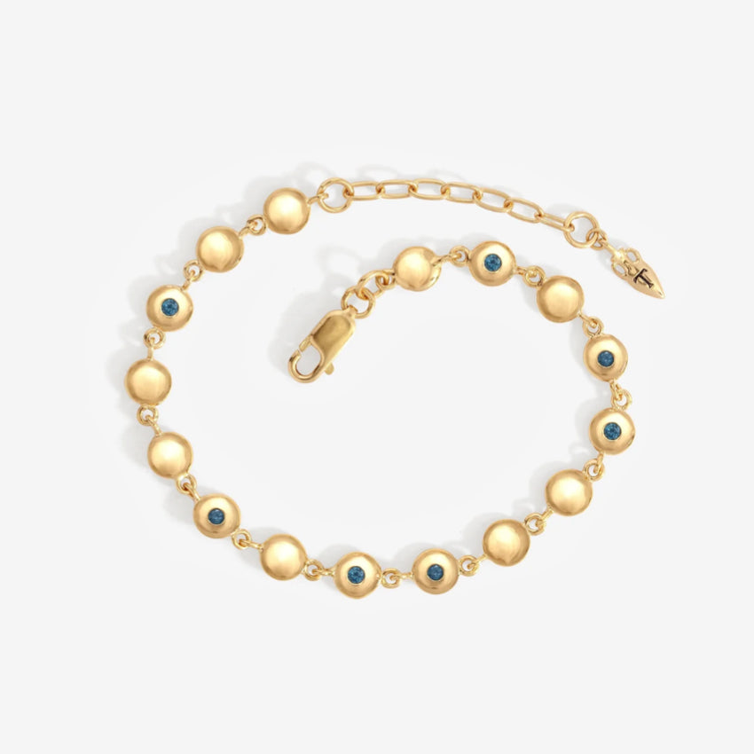 The Temple Of The Sun Mavi Chain Bracelet in Gold on a grey background