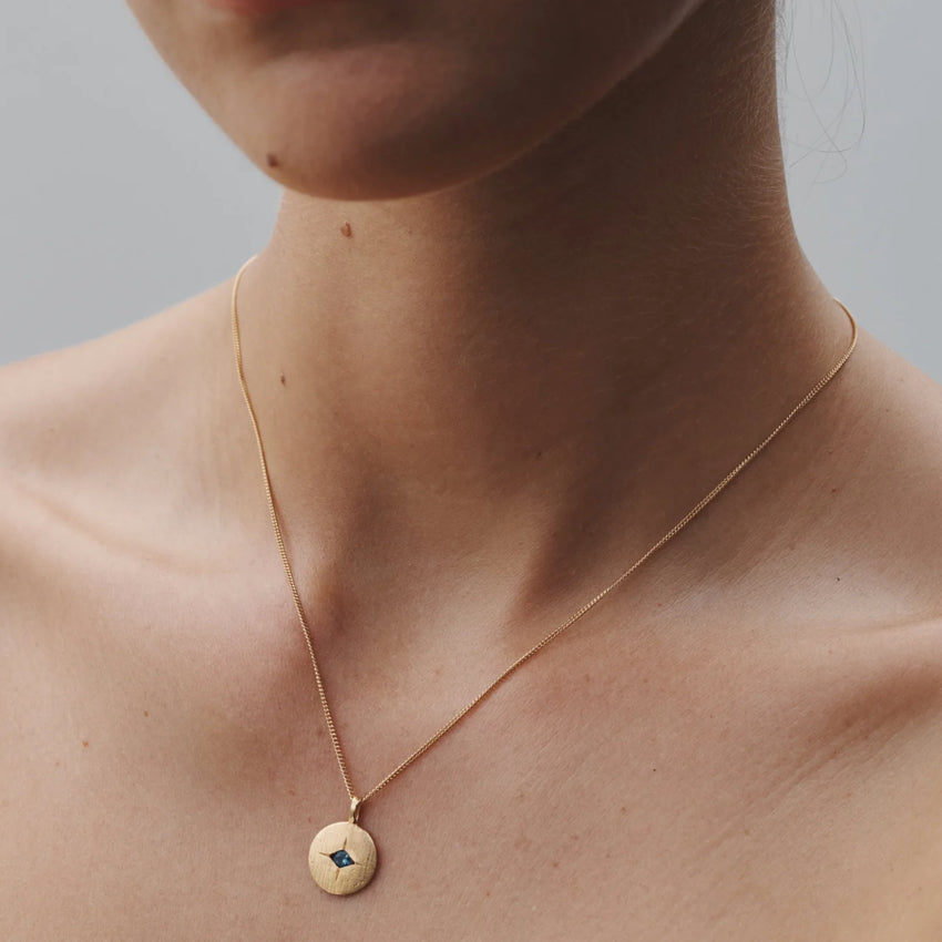The Temple Of The Sun Mavi Eye Necklace in Gold on a model's neck 