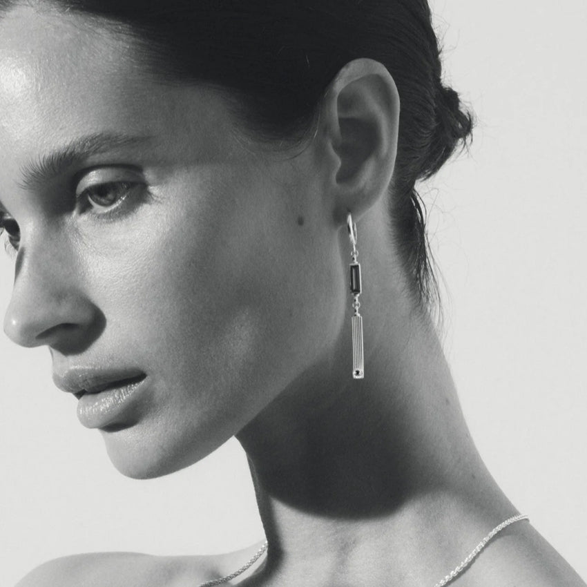 The Temple Of The Sun Pele Earrings in Sterling Silver on a model in black and white