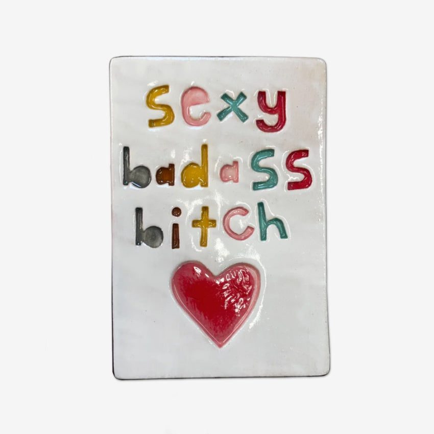 The Monster Company Large Wall Tile with Sexy Badass Bitch on it on a blank background.