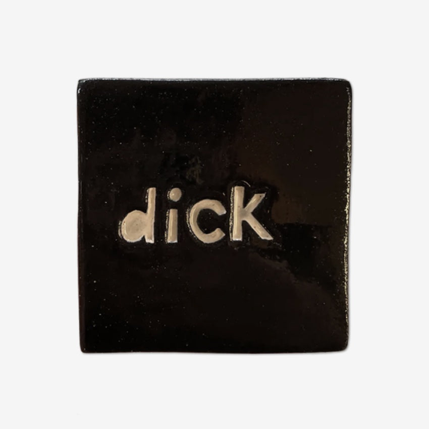The Monster Company black square tile with ' dick' text on a grey background