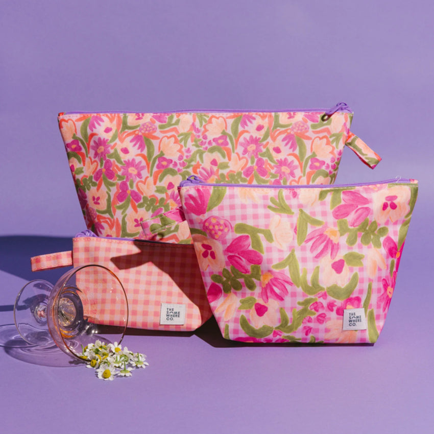 The Somewhere Co Handy Pouches in Petal Party print on a purple background