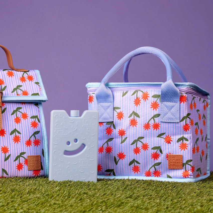 The Somewhere Co Lunch Bag in Sunburst on grass next to a icepack 