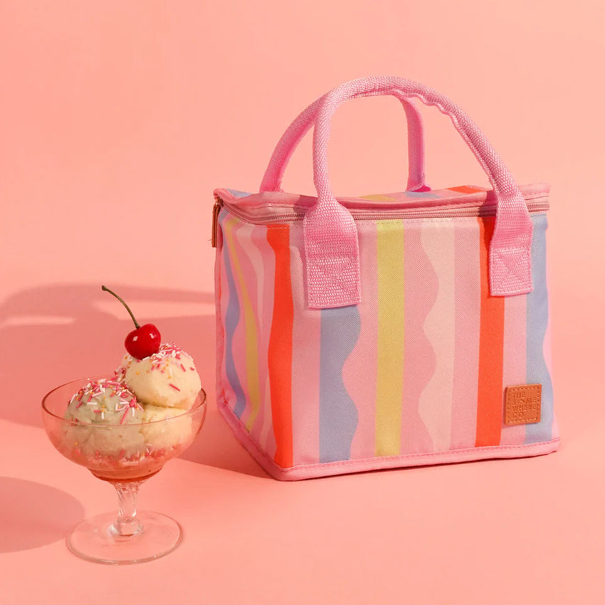 The Somewhere Co's Lunch Bag in Sweet Siesta pattern on a beach backdrop next to an icecream sundae