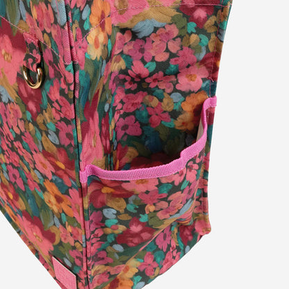 A closeup of the Somewhere Co Ultimate Tote's drink bottle holder in the Amongst the Flowers pattern on a blank background