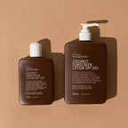 The We Are Feel Good Inc Coconut SPF50+ Sunscreen 200ml and 400ml on a brown background 