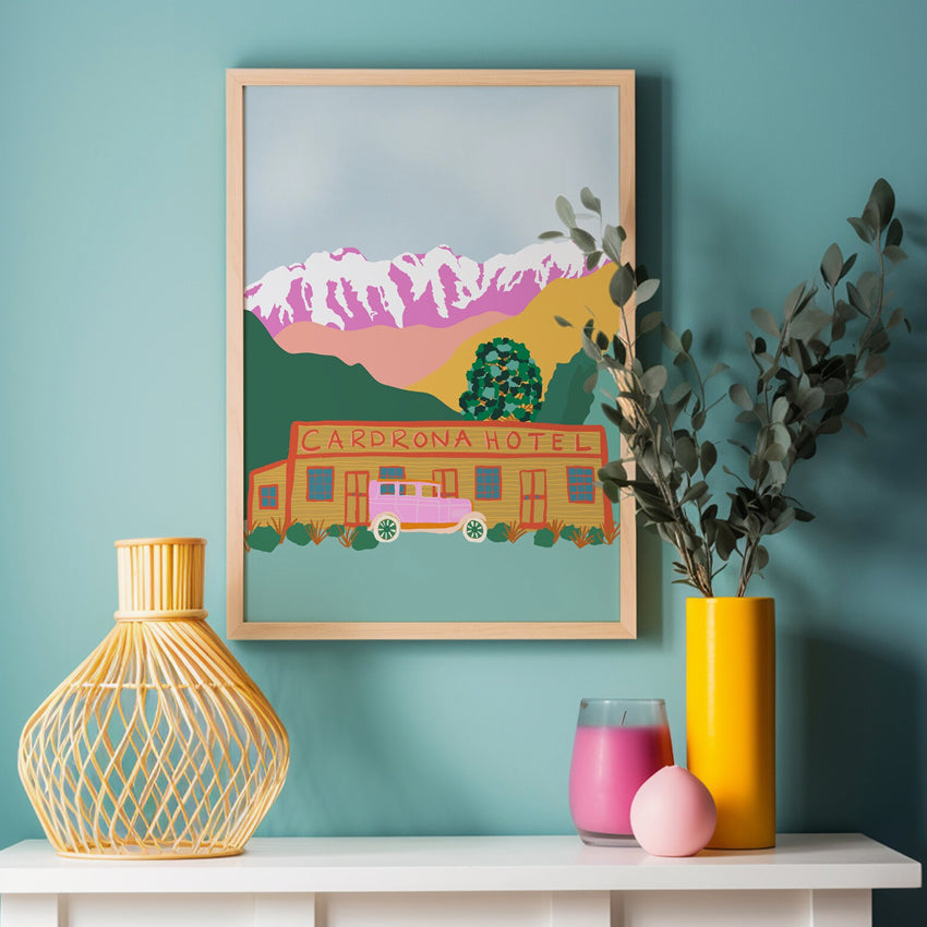 The West Moor Design Cardrona Art Print in a wooden frame hanging on a wall above vases