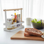 The Yamazaki Tosca Seasoning Rack with seasonings and oil in it on a bench with bread and salad