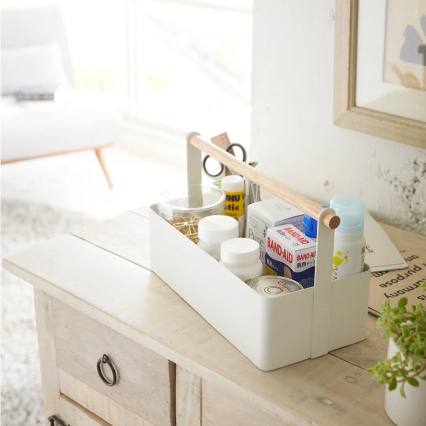 The Yamazaki Tosca Tool Box in Large on a side table with bathroom items in it 