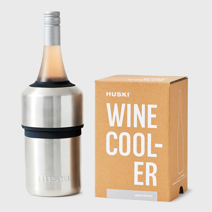 The Huski Wine Cooler in Brushed Stainless with a wine bottle in it and next to its box on a blank background