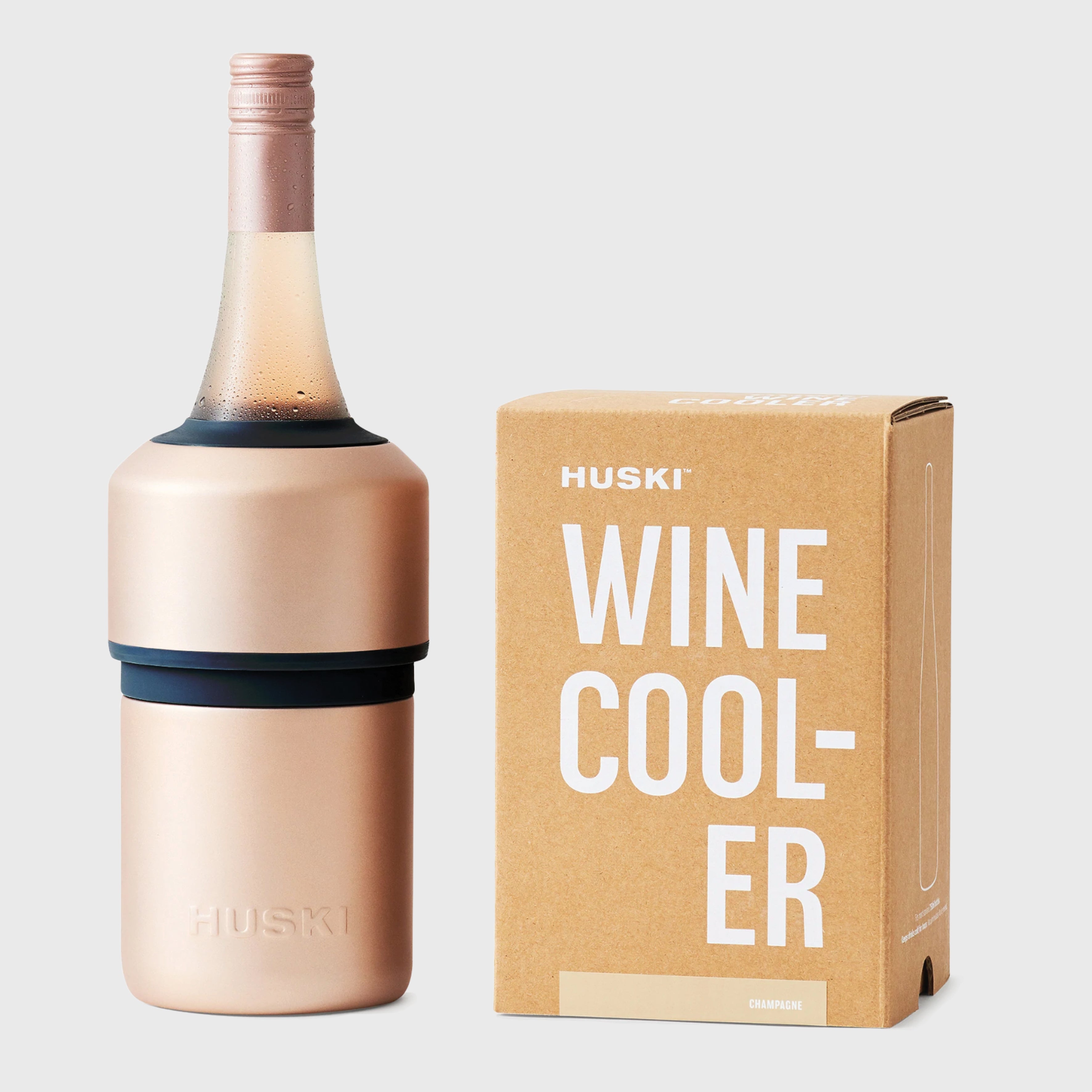 The Huski Wine Cooler in Champagne with a wine bottle in it and next to its box on a blank background