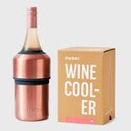 The Huski Wine Cooler in Rose with a wine bottle in it and next to its box on a blank background