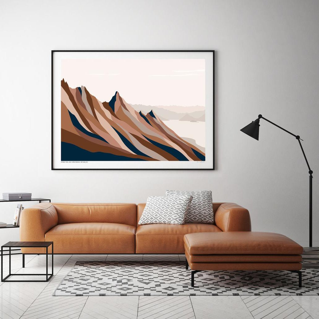 The Bridget Hall Isthmus Peak Trail Art Print in a black frame hanging above a couch