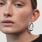 The Nina Gordon Voyage Door Knocker Earrings in Silver on a model