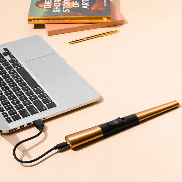 The Flint Rechargeable Lighter in Gold plugged into a laptop and charging