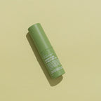 The We Are Feel Good Inc Kakadu Plum SPF50+ Lip Balm on a green background