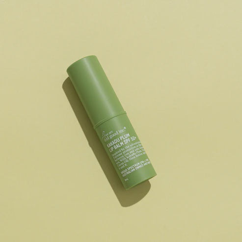 The We Are Feel Good Inc Kakadu Plum SPF50+ Lip Balm on a green background