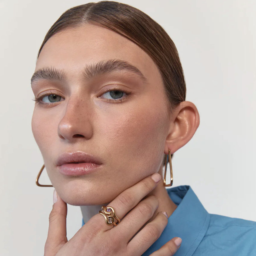 Two of the Nina Gordon Lucid Rings with a Amethyst in Gold on a model's finger