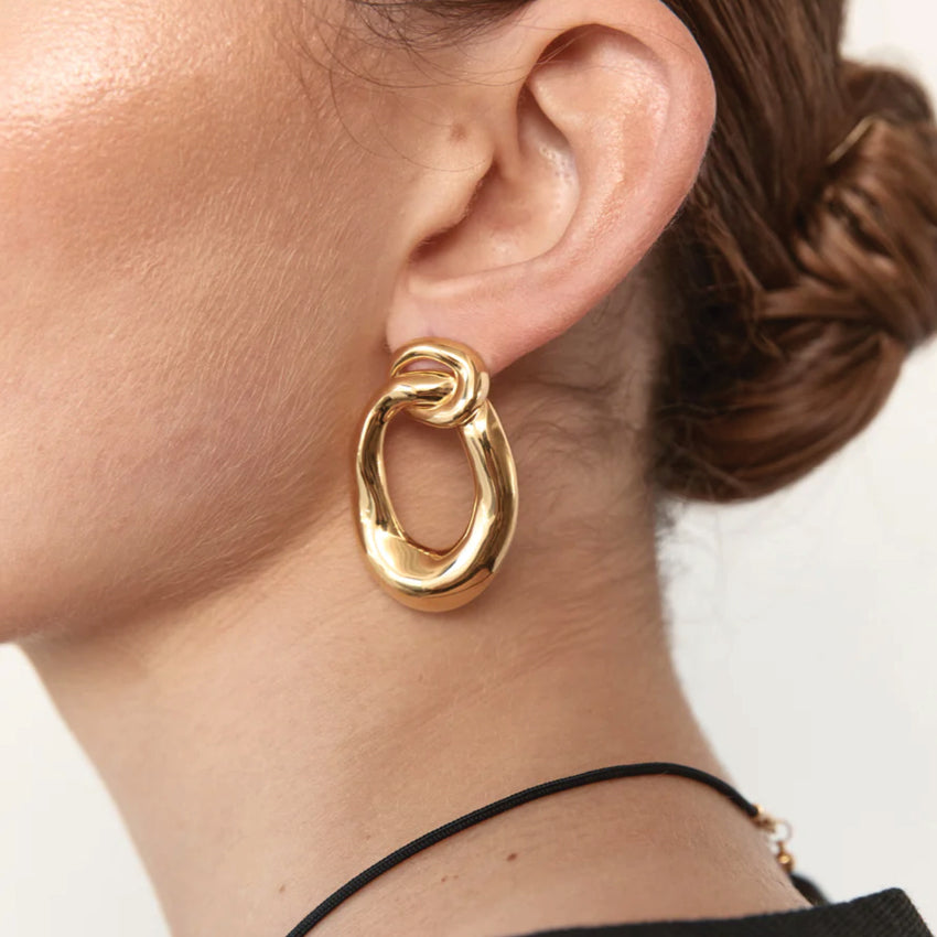 The Nina Gordon Voyage Door Knocker Earrings in Gold on a model