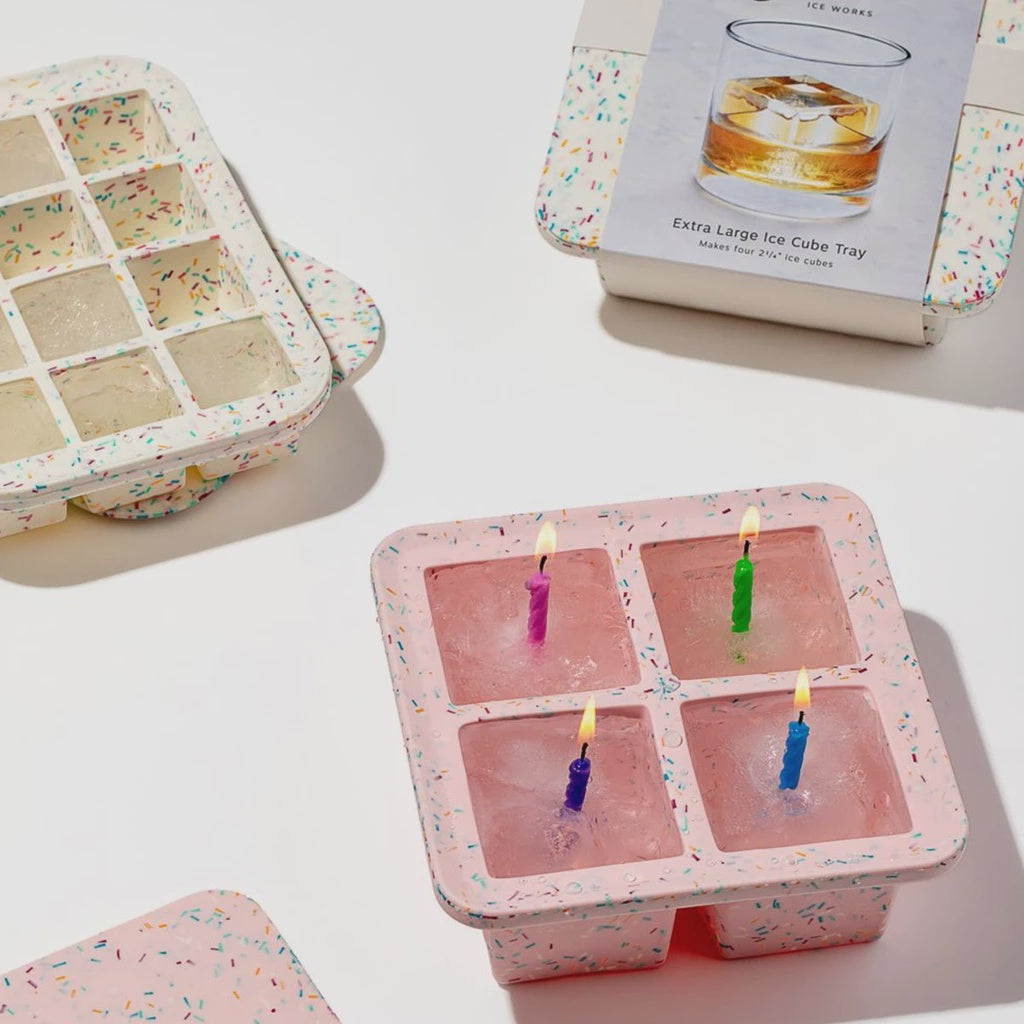 The Peak XL Ice Cube Tray in Speckled White and Pink with ice and candles in one.