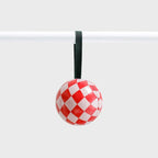 The Lettuce Pink Check Bauble hanging on a rod