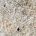 The Silver Linings Collective Solace Necklace in Silver on a textured background