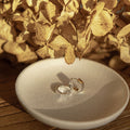 The Silver Linings Collective Whistledown Solid Hoops in Silver on a textured bowl with some flowers