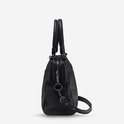 A side view of the Status Anxiety Last Mountains Bag in Black on a blank background