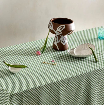 The Bonnie and Neil Table Cloth in Sage Tiny Checkers folded on a table