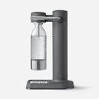 The side profile of the Aarke Carbonator 3 in Matte Black with the PET Water Bottle in it on a blank background