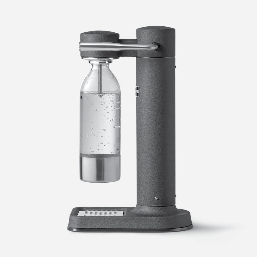 The side profile of the Aarke Carbonator 3 in Matte Black with the PET Water Bottle in it on a blank background